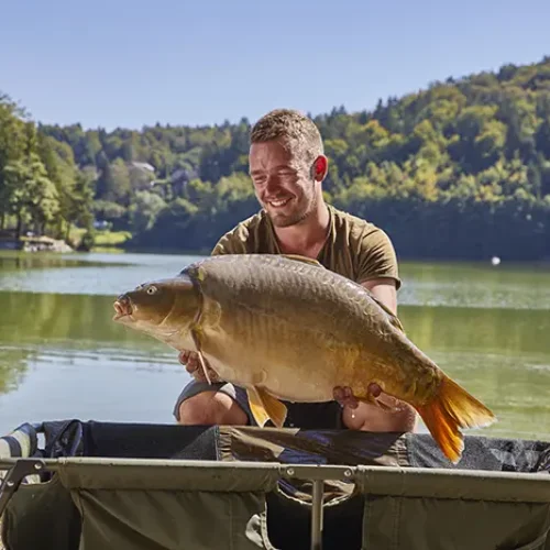 A male demonstrating the giant fish caught in the Smartinsko lake, municipality Celje, Savinjska region, Slovenia